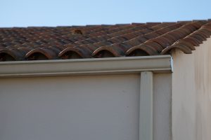 Beige aluminum gutter system on the corner of a house